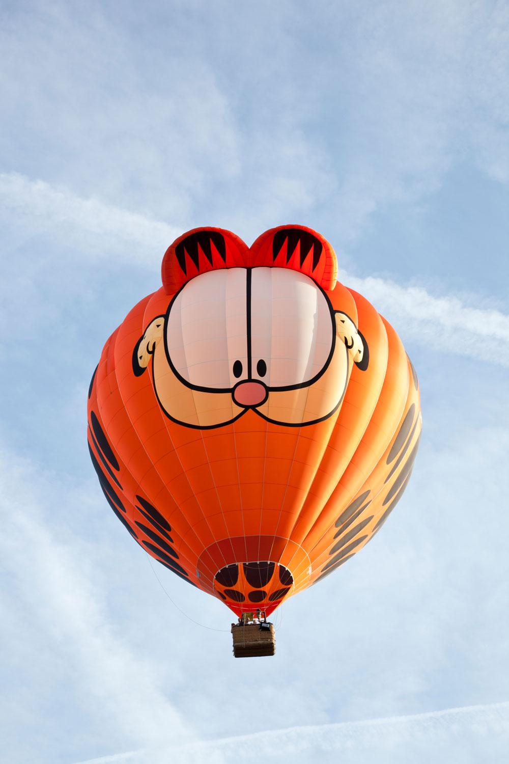 A huge Garfield themed air balloon flying in the sky
